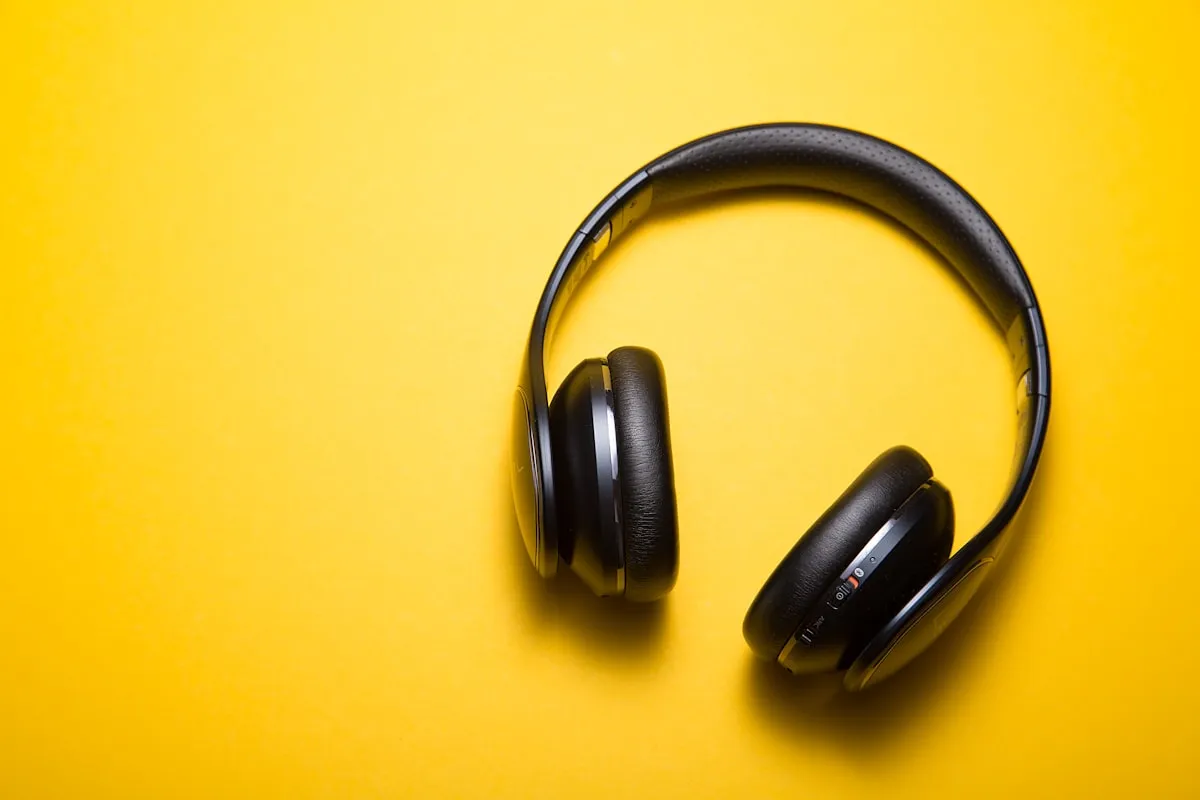 Black wireless over-ear headphones on a yellow background