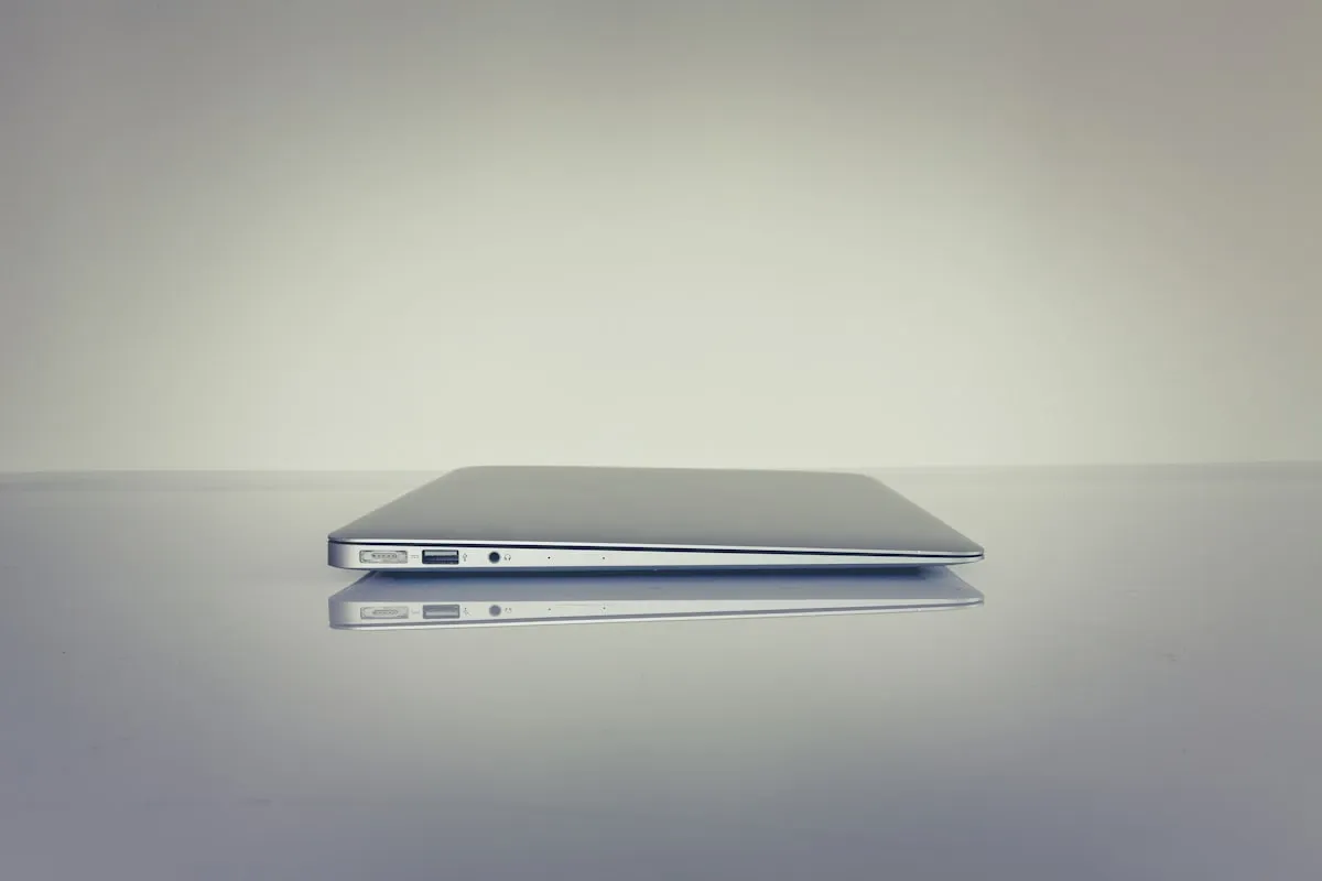 A slim laptop closed, in profile on a white table