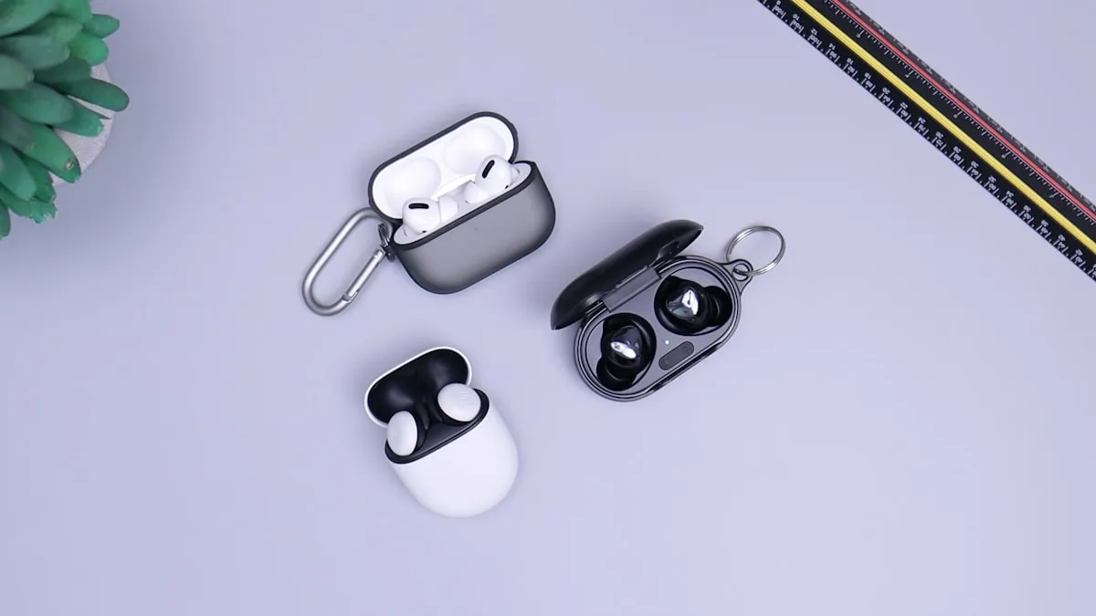 Wireless earbuds with their open charging cases on a desk