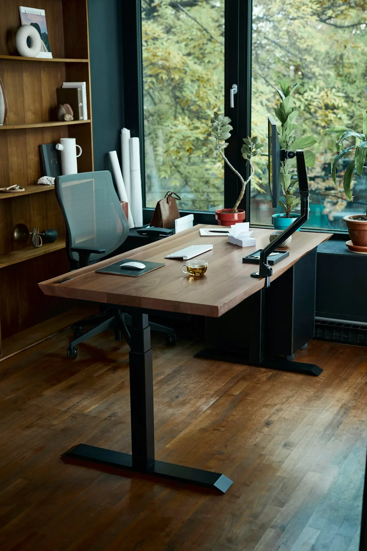 A height-adjustable desk by a window in a home office