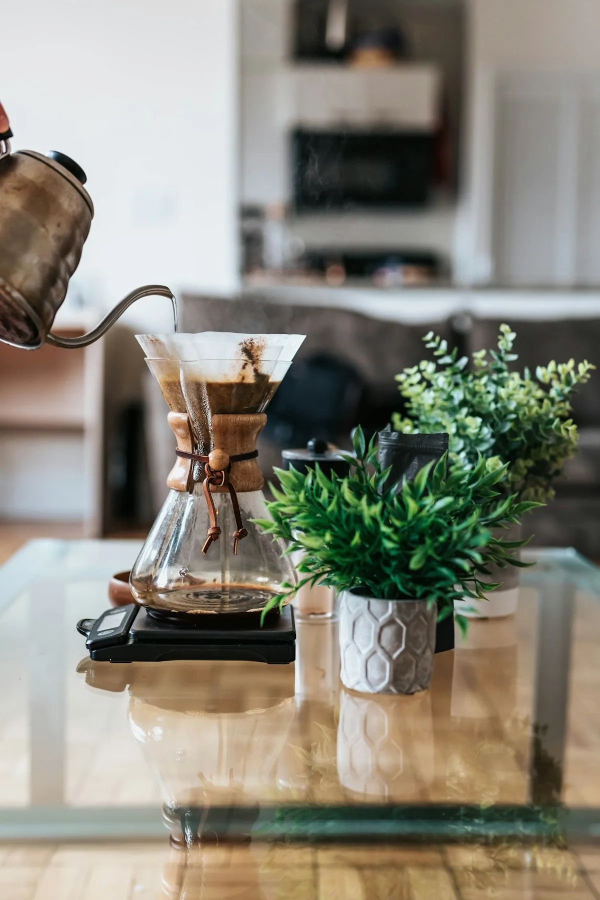 A gooseneck kettle pouring water into a pour-over brewer